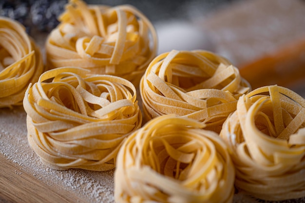 Homemade fettuccine pasta folded in the shape of a nest Home cooking with ingredients for homemade traditional Italian fettuccine pasta