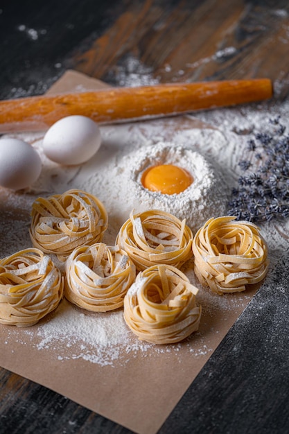 Homemade fettuccine pasta folded in the shape of a nest Home cooking with ingredients for homemade traditional Italian fettuccine pasta