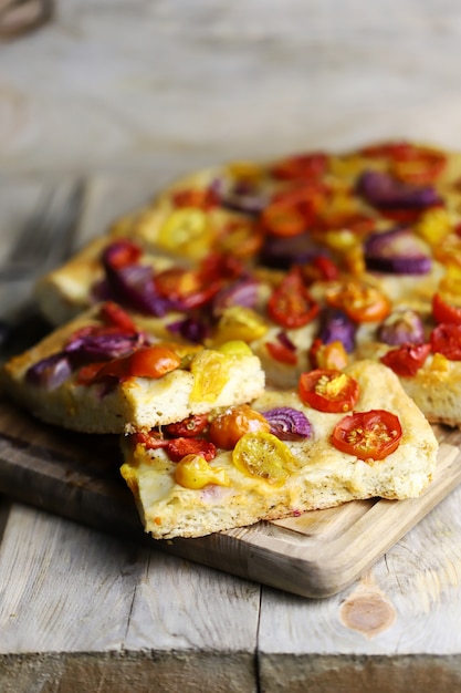 Homemade focaccia with cherry tomatoes and blue onions.