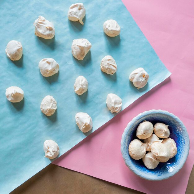 Homemade french milkcolored meringues on blue paper