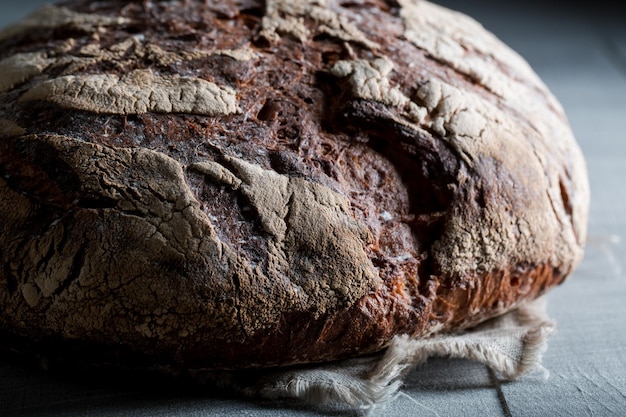 Homemade and fresh bread with several grains on dark table