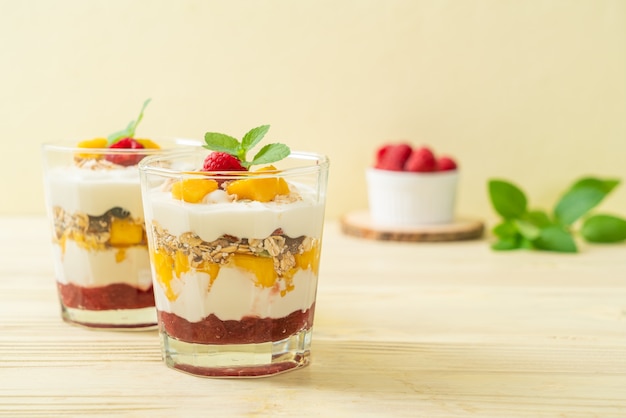 homemade fresh mango and fresh raspberry with yogurt and granola - healthy food style