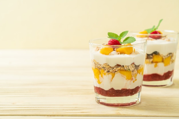 homemade fresh mango and fresh raspberry with yogurt and granola - healthy food style