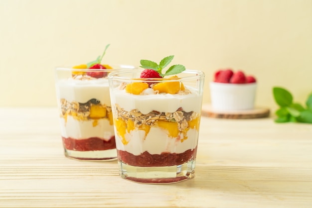 homemade fresh mango and fresh raspberry with yogurt and granola - healthy food style