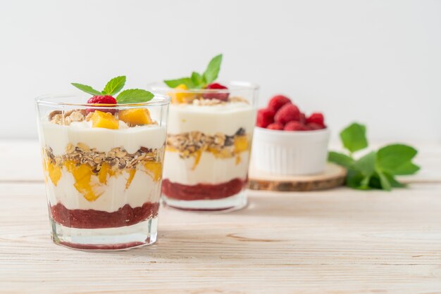 homemade fresh mango and fresh raspberry with yogurt and granola - healthy food style