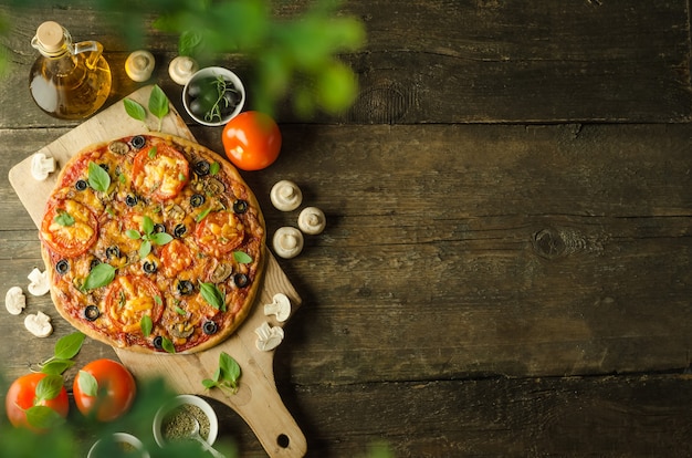 Homemade fresh vegetarian pizza with cheese and mushrooms on wooden background with copy space