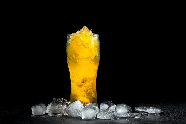 Homemade frozen beer slushie cocktail in a glass with ice on black background