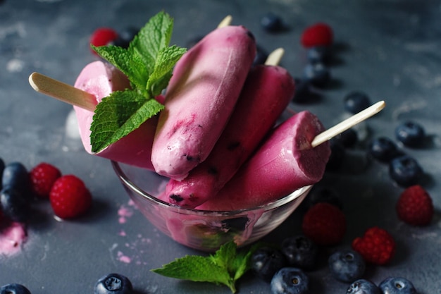 Homemade frozen fruit popsicles with fresh natural raspberry and blueberry icecream with berries