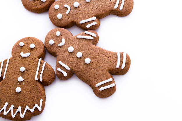 Homemade gingerbread cookies decorated with white icing on white background.