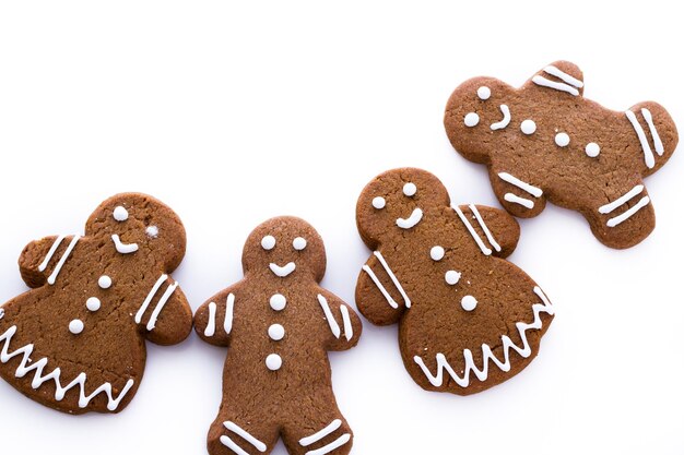 Homemade gingerbread cookies decorated with white icing on white background.