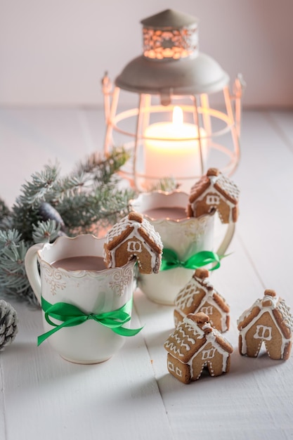 Homemade gingerbread cottages with tasty cocoa in Christmas winter evening