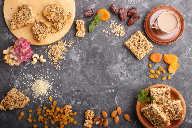 Homemade granola from oat flakes, dates, dried apricots, raisins, nuts with a cup of coffee. Top view, frame background