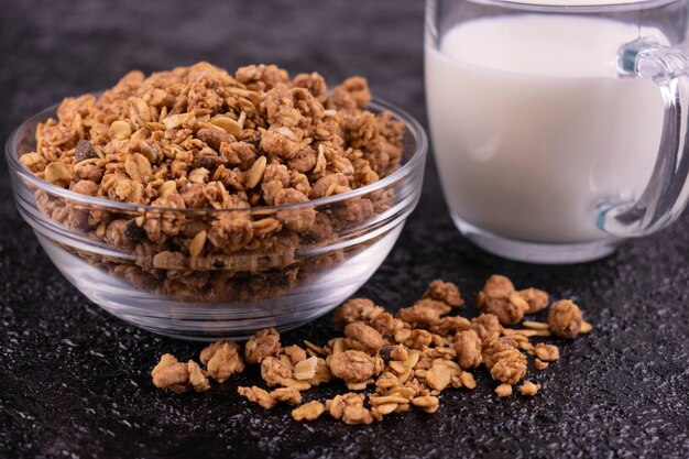 Homemade granola and milk on a black background Closeup