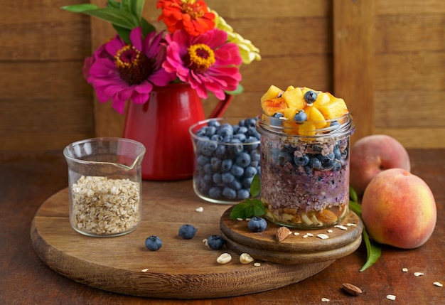 Homemade granola muesli with blueberry and yogurt in glasses on rustic wooden background Healthy breakfast