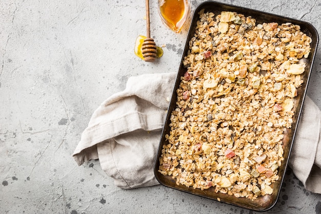 Homemade Granola with oat, honey and nuts in a baking tray