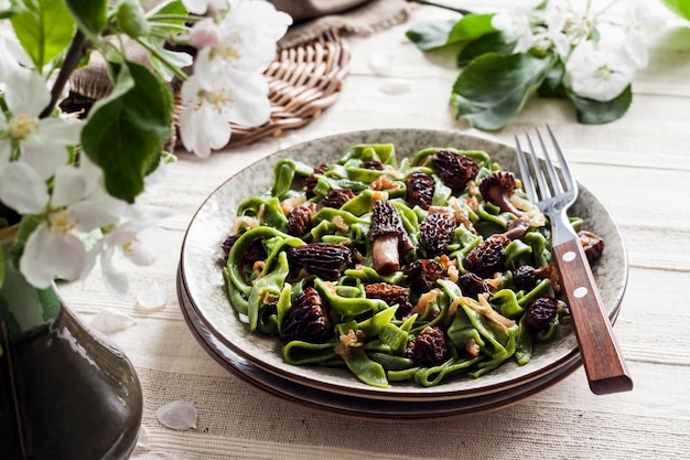 Homemade green nettle pasta with fried spring morel mushrooms