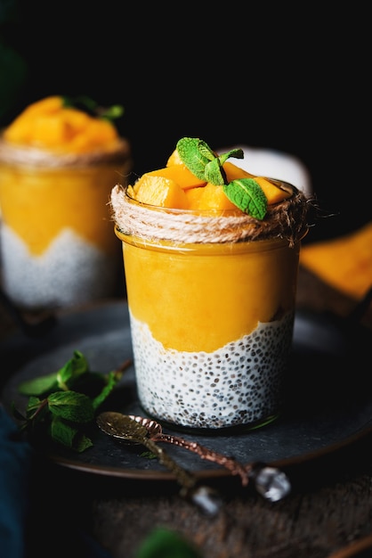 Homemade healthy breakfast, chia pudding with coconut milk and mango on a wooden table