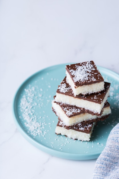 Homemade healthy energy organic raw vegan coconut bars with chocolate on a kitchen table