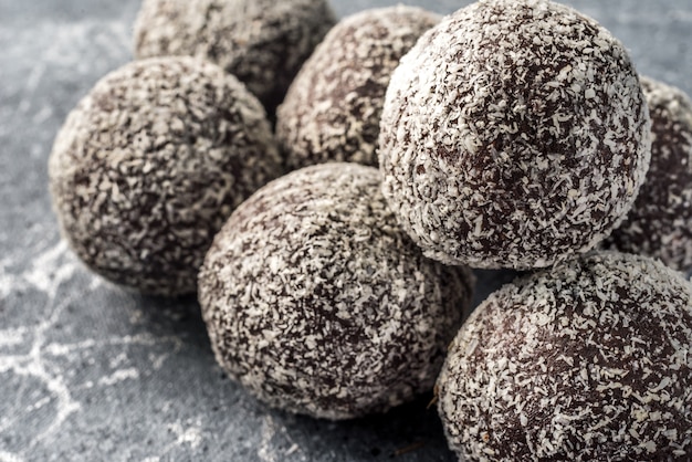 Homemade healthy protein energy balls in a coconut bowl with dried apricots, raisins, walnuts, almonds and coconut. Healthy sweet food