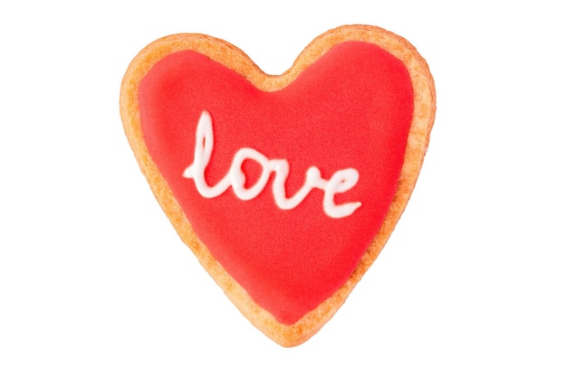 Homemade heart shaped cookie with red icing and lettering LOVE isolated on white background