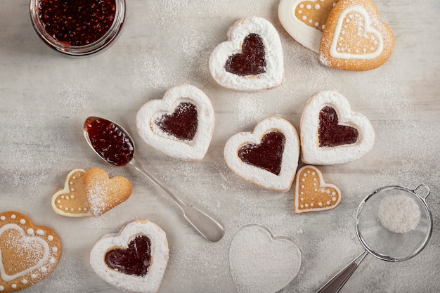 Homemade heart shaped  cookies with raspberry jam on white wooden table  for Christmas or  Valentine's day. Top view.