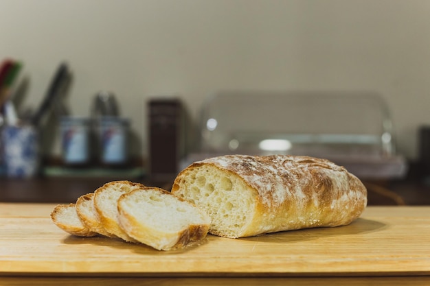 Homemade Italian ciabatta bread cut in slices on wooden board