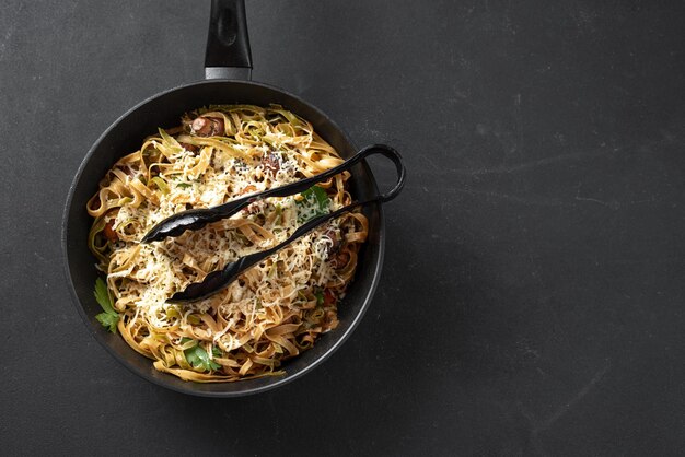 Homemade italian fettuccini or alfredo pasta also called funghi porcini cooked in a cast iron skille