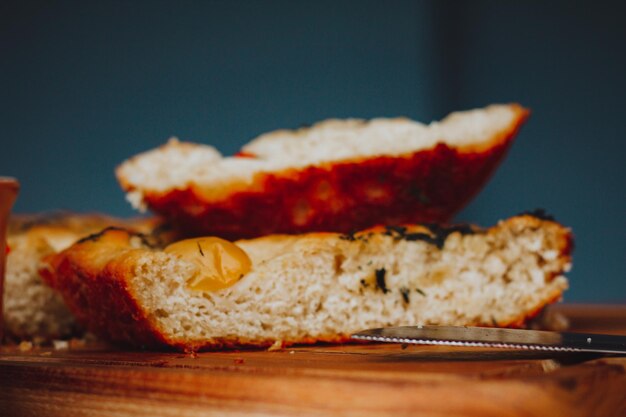 Homemade Italian Focaccia, with tomato and olive oil on a rustic wooden background.