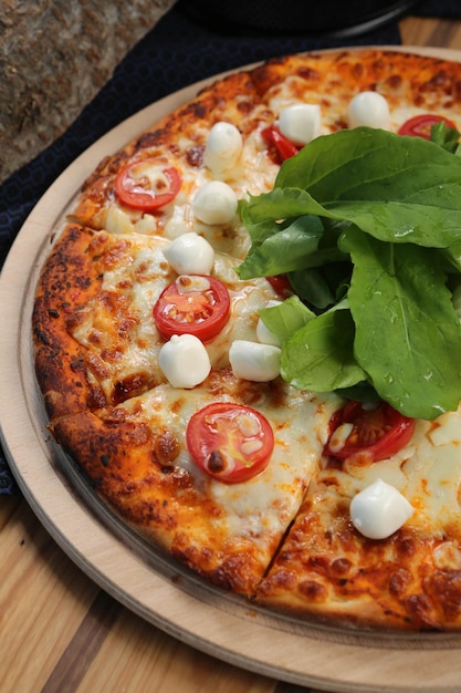 Homemade Italian pizza with mozzarella cheese salami tomato sauce pepper arugula and spices