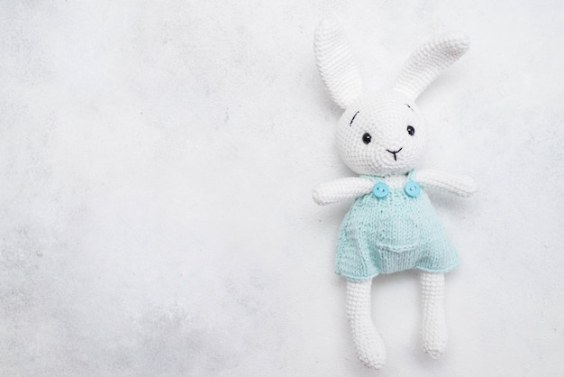 Homemade knitted toy hare on a light background Postcard