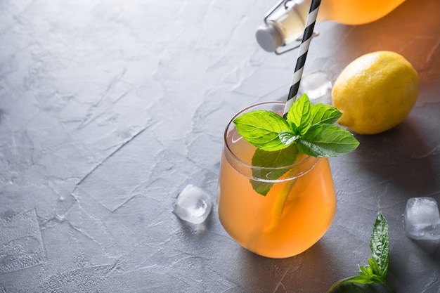 Homemade Kombucha tasty drink in bottle and glass with lemon, mint.