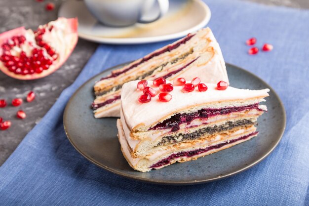 Homemade layered cake with pomegranate jam and a cup of coffee. side view