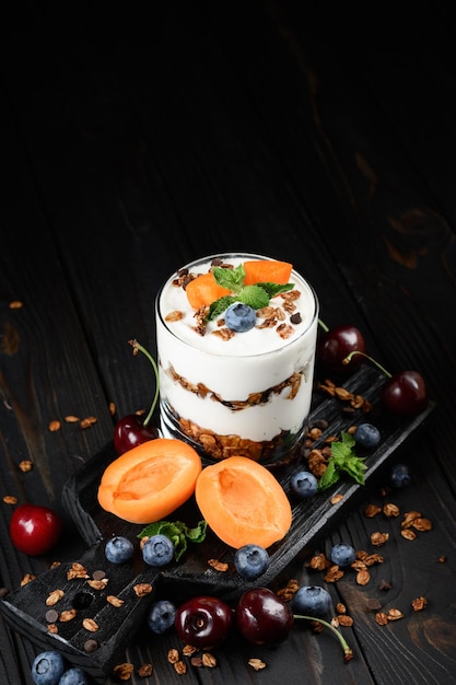 Homemade layered dessert with fresh apricot blueberry cherry cream cheese or yogurt granola