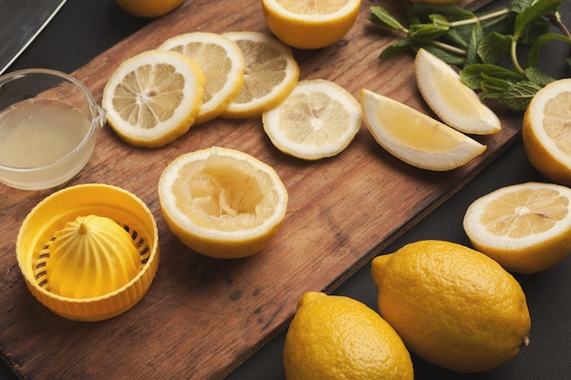 Homemade lemonade background. Lemons, juice squeezer, mint and ginger - ingredients for refreshing tropical drink