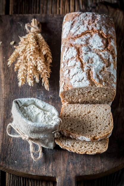 Homemade loaf of bread with several grains on wooden table