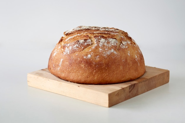 Homemade loaf of white bread on a wooden table