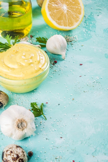 Homemade mayonnaise sauce with ingredients - lemon, eggs, olive oil, spices and herbs