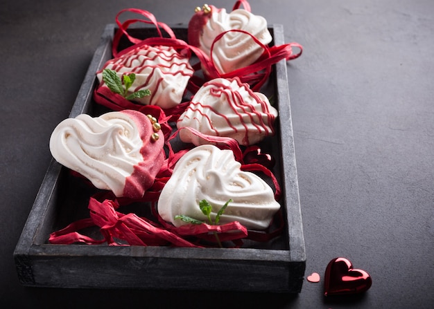 Homemade meringues in heart shape in old wooden box for Valentine's day