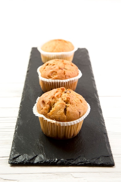 Homemade muffins on the black tray, selective focus