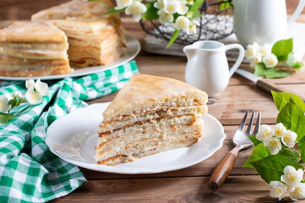 Homemade naked layered vanilla cake with whipped cream on a wooden table