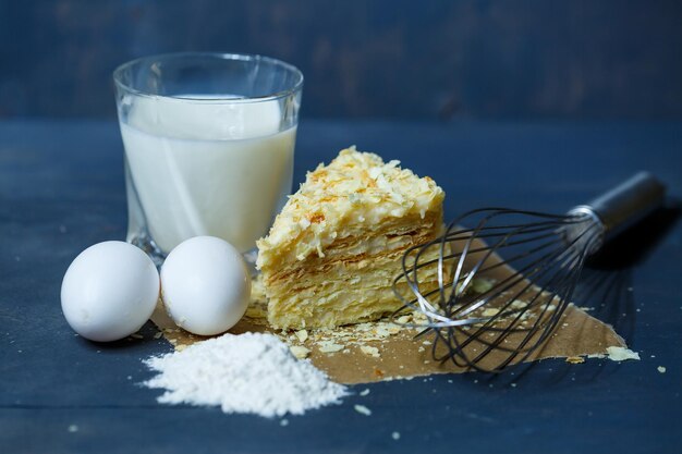 Homemade Napoleon cake with cream on a gray background