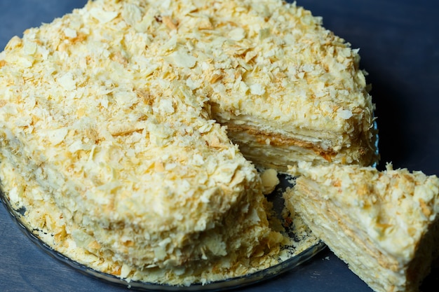 Homemade Napoleon cake with cream on a gray background.