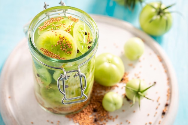 Homemade and natural pickled green tomatoes with allspice and mustard