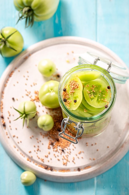 Homemade and natural pickled green tomatoes with mustard and vinegar