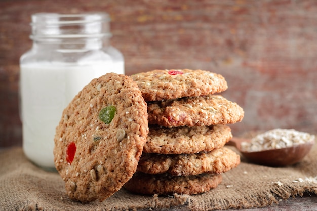 Homemade oat biscuits and glass of milk on a wooden background