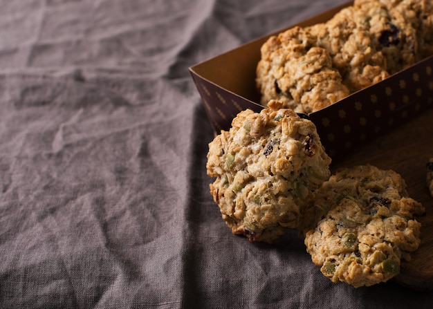 Homemade oat cookies on dark grey or brown background, healthy snack, copy space