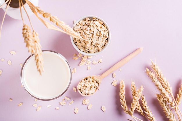 Homemade oat milk in a glass and oatmeal on the table Alternative to lactose Top view