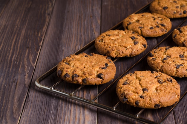 Homemade oatmeal cookies on cooling rack. Wooden background