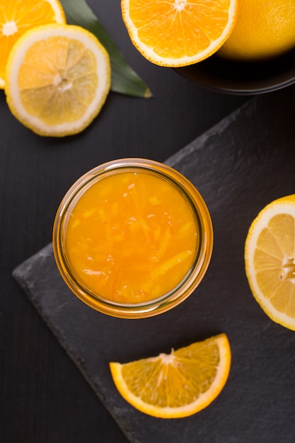 Homemade orange jam in a jar on a black stone table