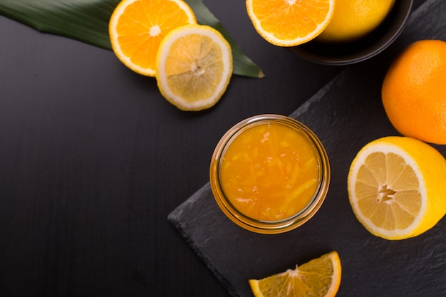 Homemade orange jam in a jar on a black stone table